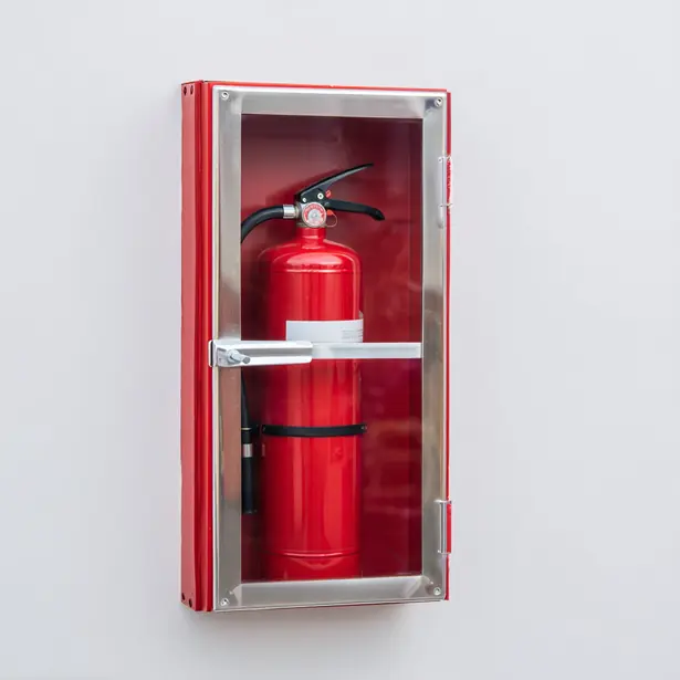 Red fire extinguisher in a wall cabinet